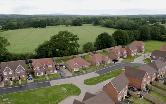 Aerial shot of new homes next to a green field