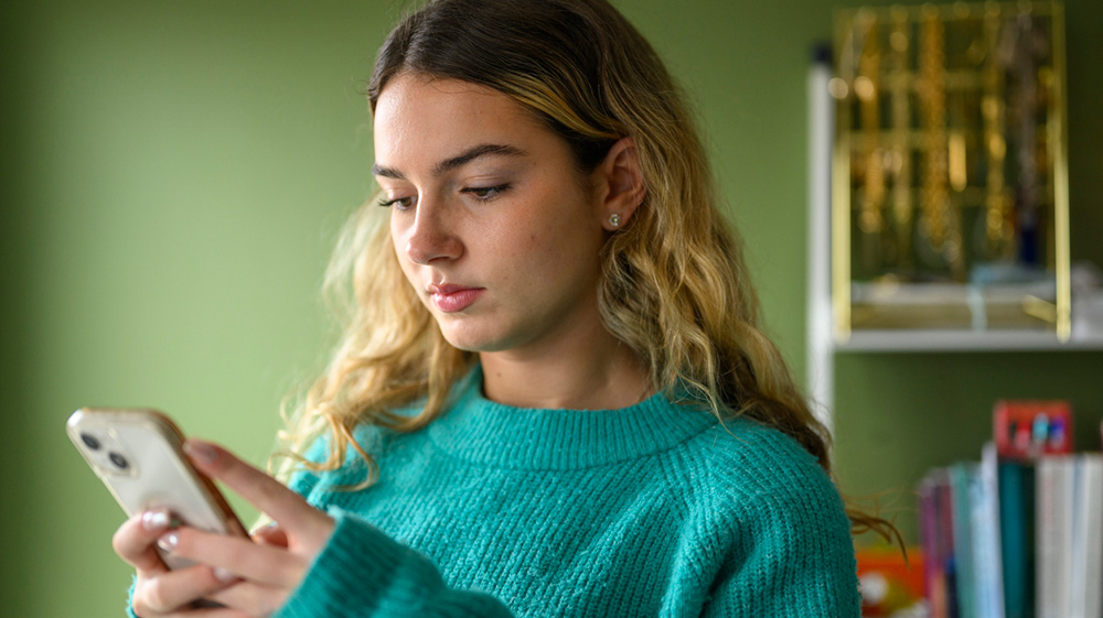 A woman looking at her phone typing something