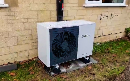 A heat pump against a wall