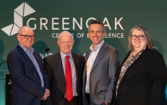 4 people stood in front of Greenoak Centre of Excellence sign